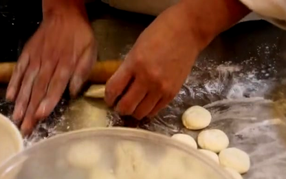 Hands folding Chinese dumplings for a step-by-step PDF recipe guide